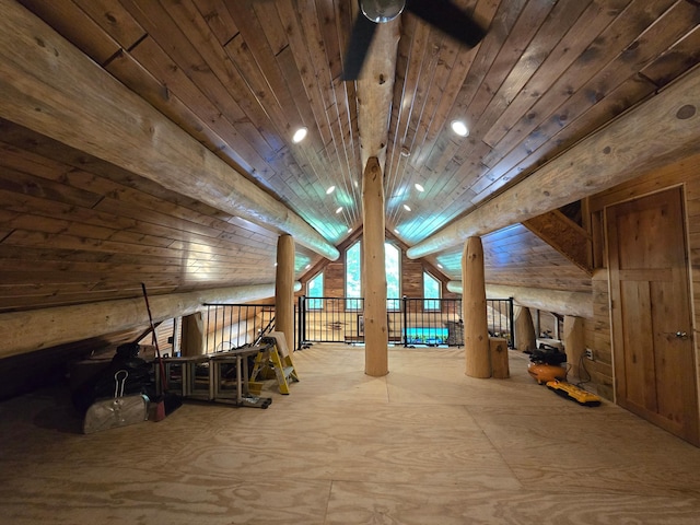 interior space featuring ceiling fan, wood walls, wooden ceiling, and vaulted ceiling