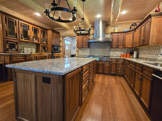 kitchen with hanging light fixtures, a kitchen island, appliances with stainless steel finishes, a chandelier, and wood-type flooring