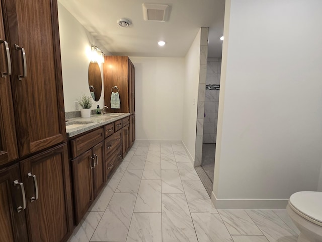 bathroom featuring vanity, toilet, and walk in shower