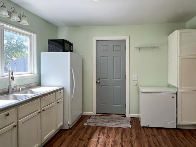 kitchen with white cabinets, dark hardwood / wood-style floors, fridge, and white fridge