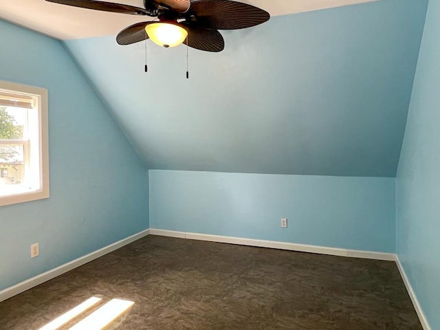 additional living space with ceiling fan, vaulted ceiling, and dark carpet