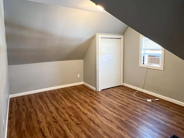 bonus room with cooling unit, lofted ceiling, and dark hardwood / wood-style floors