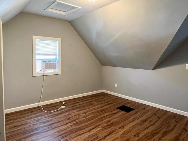 additional living space with dark wood-type flooring, cooling unit, and lofted ceiling