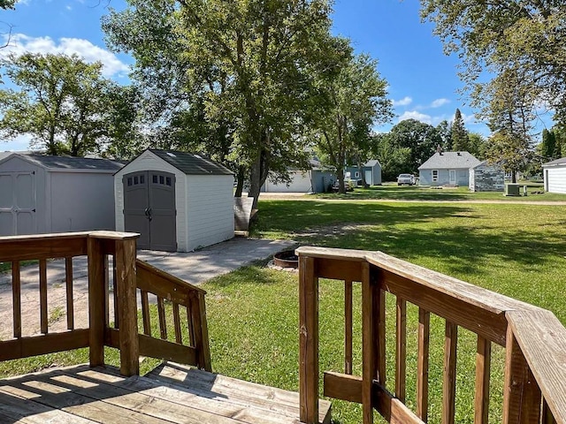 view of yard featuring a wooden deck and a storage shed