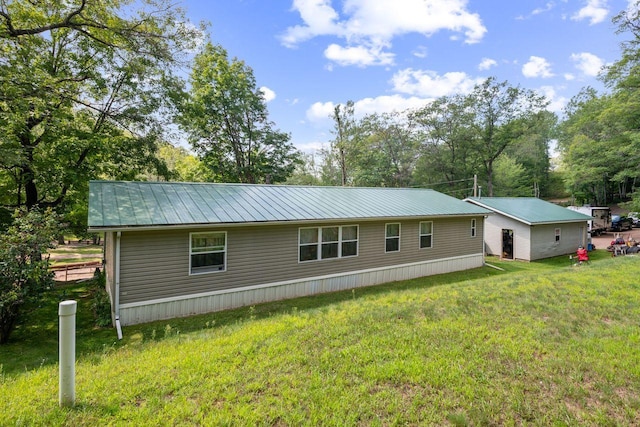rear view of house featuring a yard, metal roof, and a standing seam roof