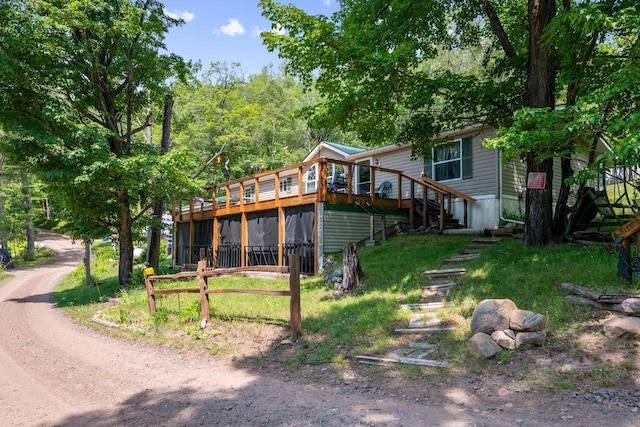 rear view of property featuring stairway and a wooden deck
