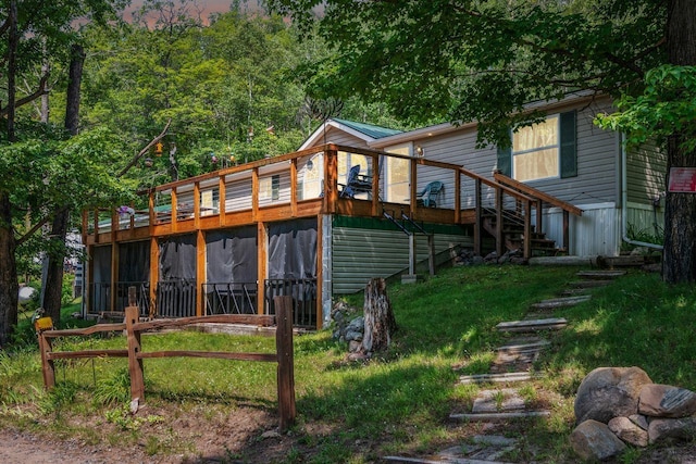 back of property with a wooden deck, stairs, and a sunroom