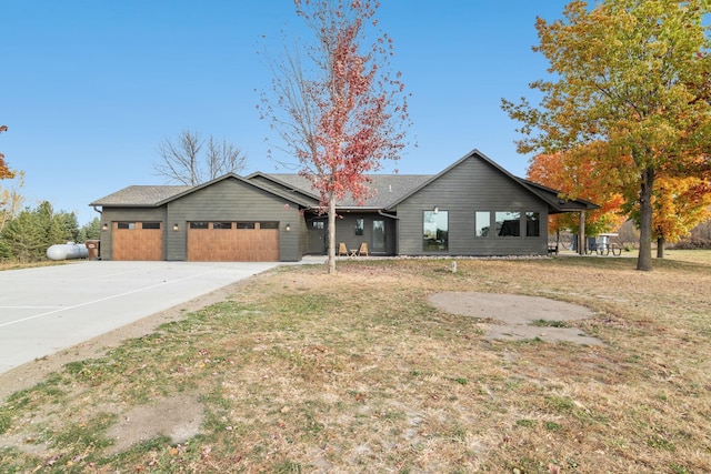 ranch-style house featuring a garage and a front yard