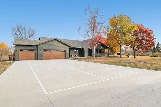 single story home featuring a garage and a front lawn