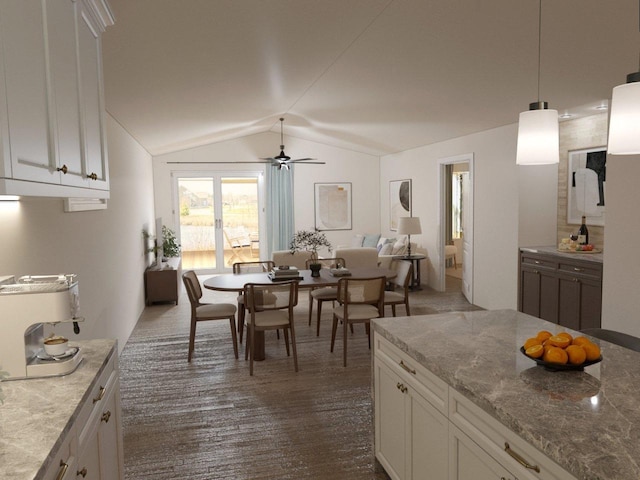 kitchen with lofted ceiling, white cabinetry, pendant lighting, ceiling fan, and light stone countertops