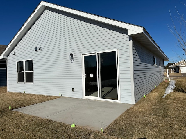 back of house with a lawn and a patio area