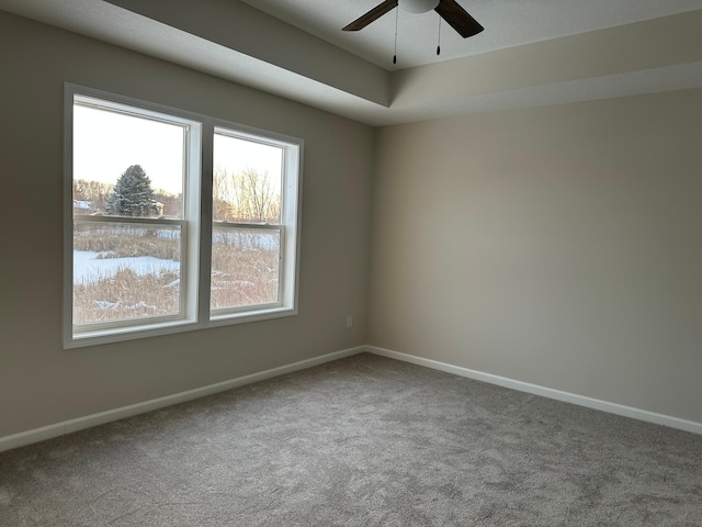 empty room with a ceiling fan, baseboards, and carpet flooring