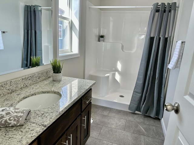 bathroom with a shower stall and vanity