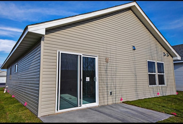 rear view of house featuring a patio area and a lawn