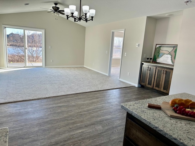 dining space featuring lofted ceiling, dark wood-style flooring, dark carpet, and baseboards