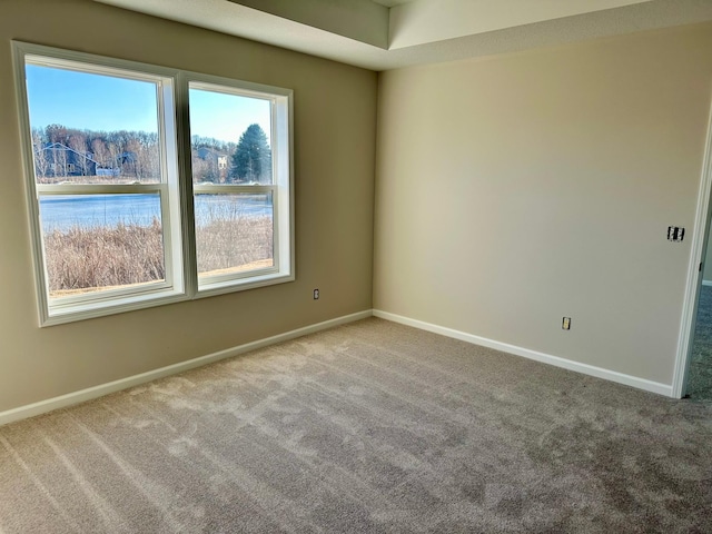 unfurnished room featuring carpet floors and baseboards