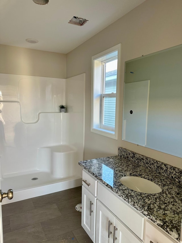 full bathroom with a walk in shower and vanity