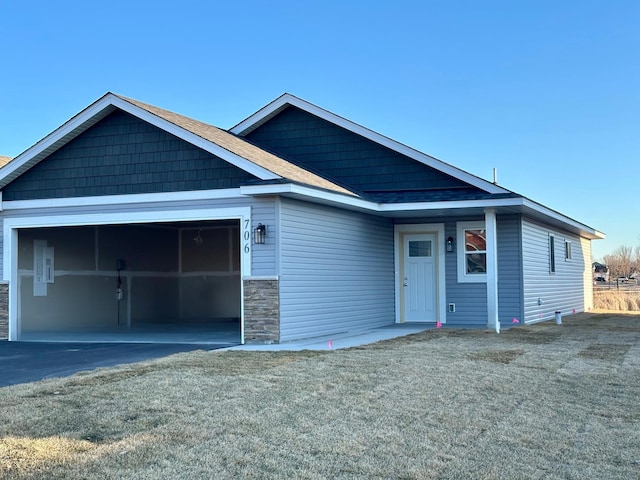 view of front of property with driveway, an attached garage, and a front yard