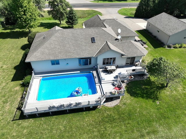 view of pool featuring a deck and a lawn