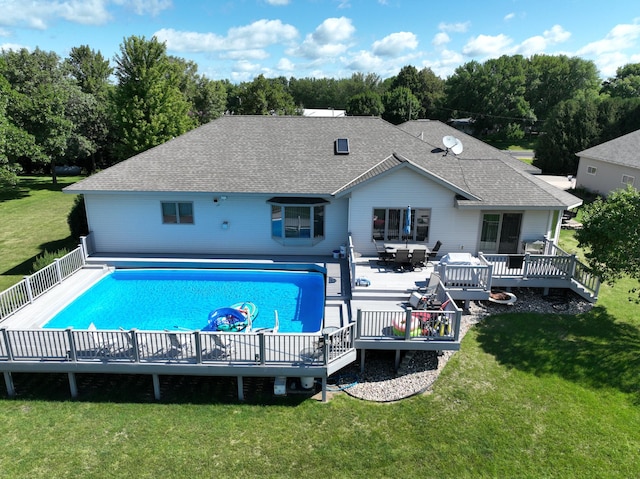 view of swimming pool with a deck and a lawn