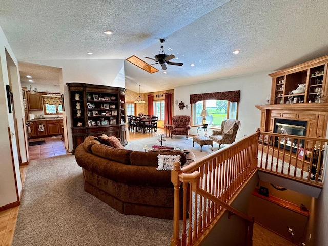 living room featuring ceiling fan, light tile patterned floors, a textured ceiling, and lofted ceiling