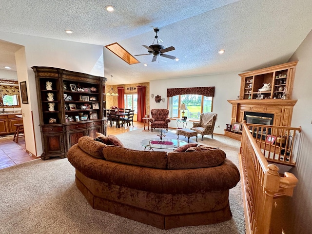 living room featuring light colored carpet, a textured ceiling, lofted ceiling with skylight, and ceiling fan