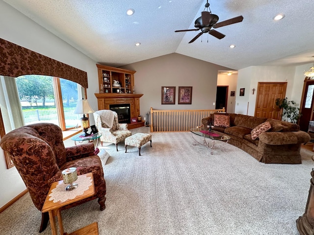 living room featuring a textured ceiling, carpet flooring, ceiling fan, and lofted ceiling