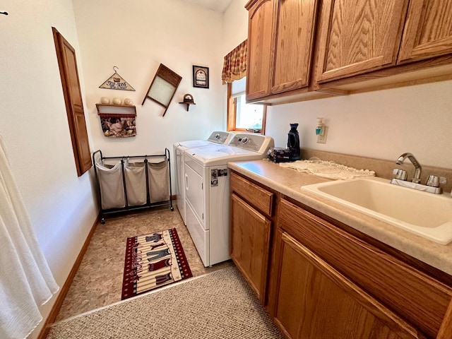 laundry room featuring sink, washing machine and clothes dryer, light tile patterned floors, and cabinets