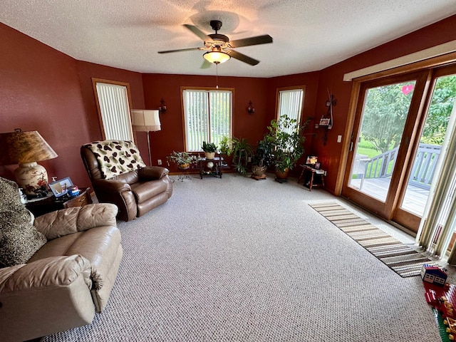 living room with ceiling fan, a textured ceiling, and carpet flooring