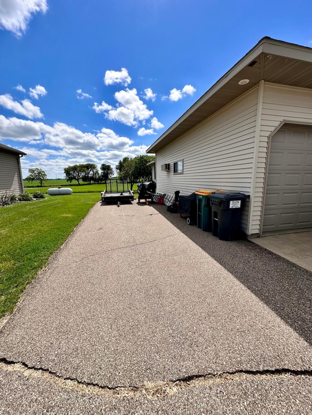 view of side of property featuring a lawn and a garage