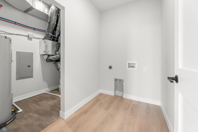 clothes washing area with hardwood / wood-style floors, water heater, electric panel, hookup for a washing machine, and hookup for an electric dryer