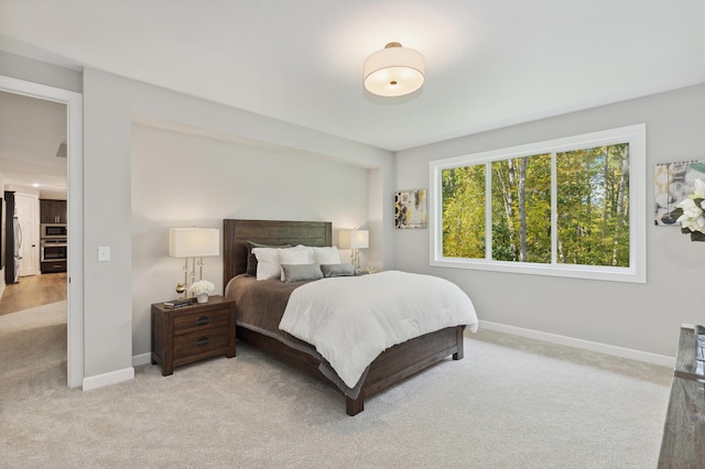 bedroom featuring light carpet and stainless steel fridge