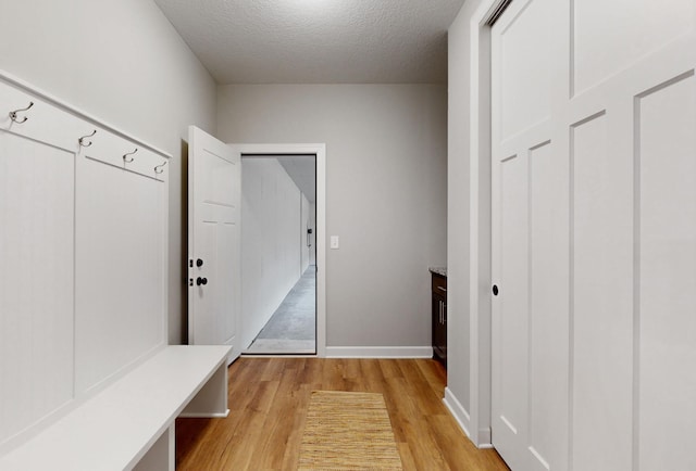 mudroom featuring a textured ceiling and light hardwood / wood-style floors