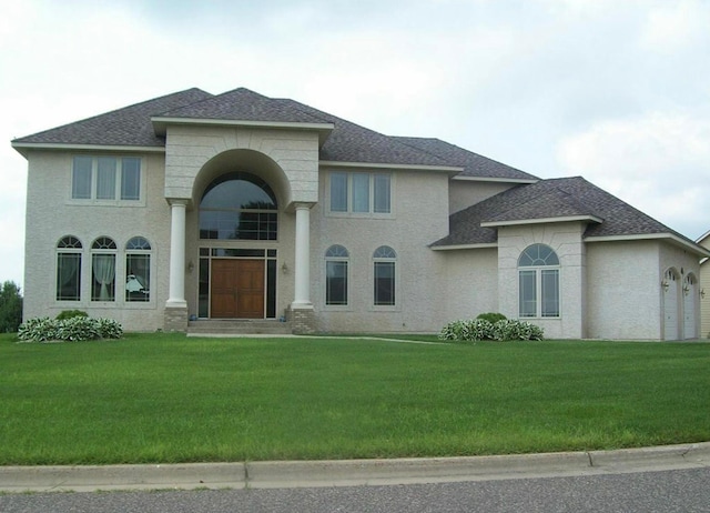 view of front of home featuring roof with shingles and a front lawn