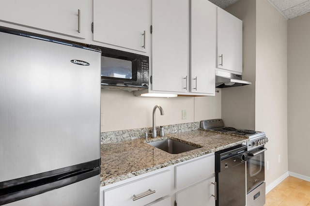 kitchen featuring wall chimney exhaust hood, white cabinetry, light stone counters, sink, and black appliances