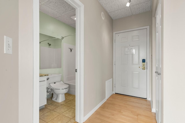 full bathroom with a paneled ceiling, toilet, shower / bathtub combination, vanity, and hardwood / wood-style flooring