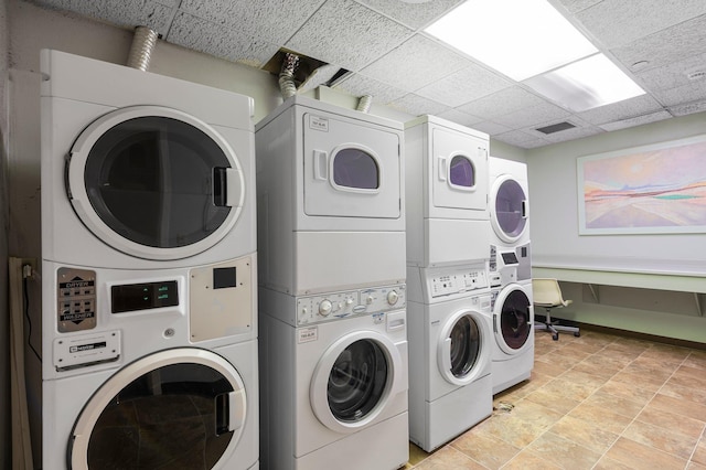 clothes washing area featuring stacked washing maching and dryer, light tile patterned floors, and washing machine and clothes dryer