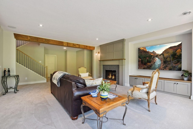 living room with a textured ceiling, light colored carpet, and a tile fireplace