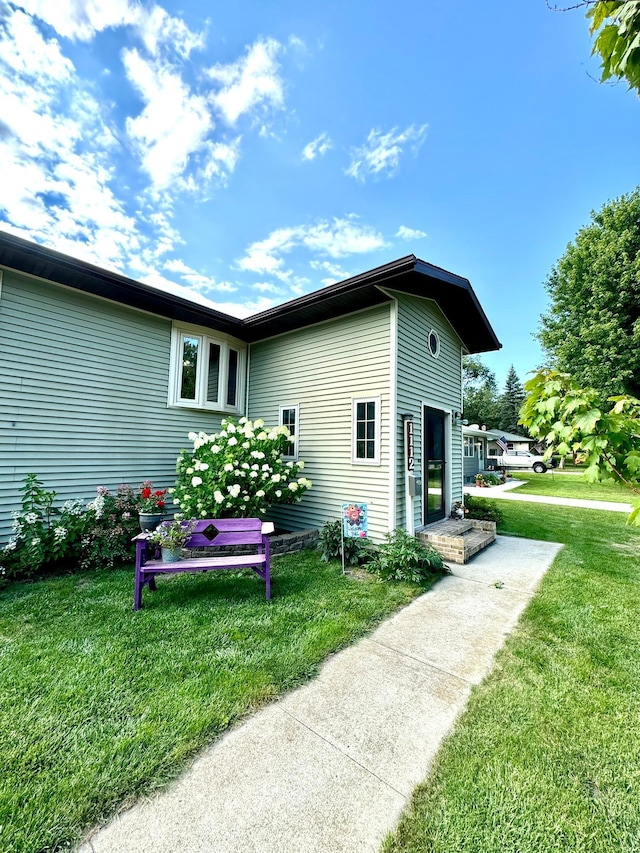 view of side of home with a yard