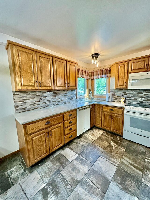 kitchen with sink, decorative backsplash, and white appliances