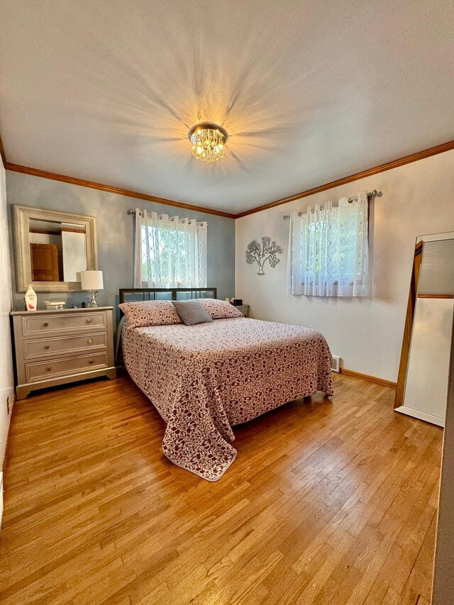 bedroom featuring crown molding and light hardwood / wood-style flooring