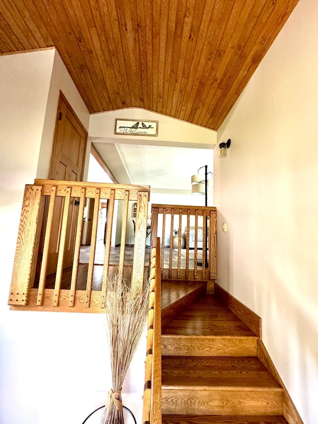 stairway with wood-type flooring, vaulted ceiling, and wooden ceiling