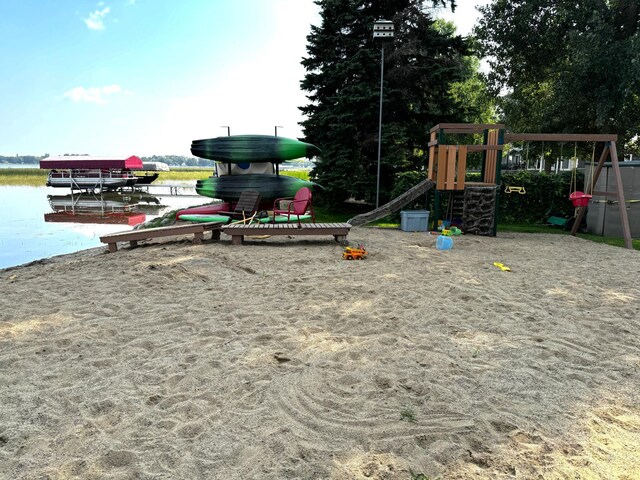 community playground featuring a dock and a water view