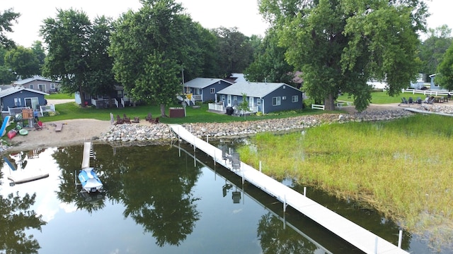 view of dock featuring a lawn and a water view