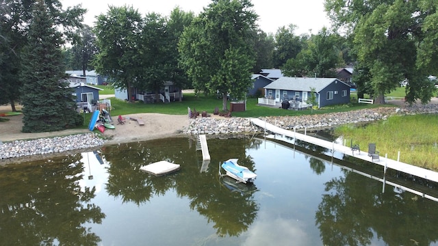 view of dock with a water view and a yard