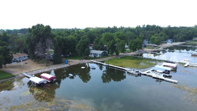 drone / aerial view featuring a water view and a wooded view