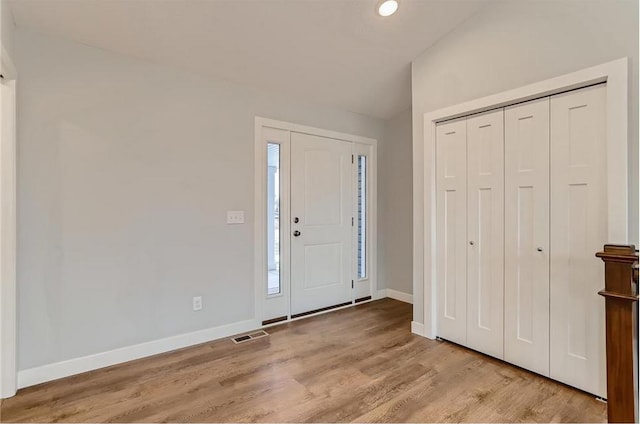 entrance foyer with light hardwood / wood-style flooring and vaulted ceiling