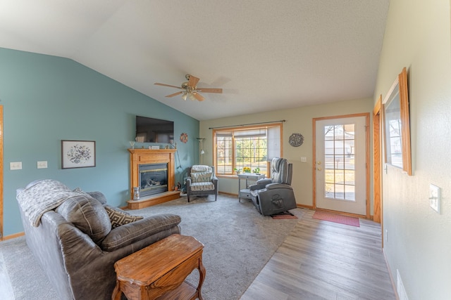 living room with ceiling fan, vaulted ceiling, and light hardwood / wood-style flooring