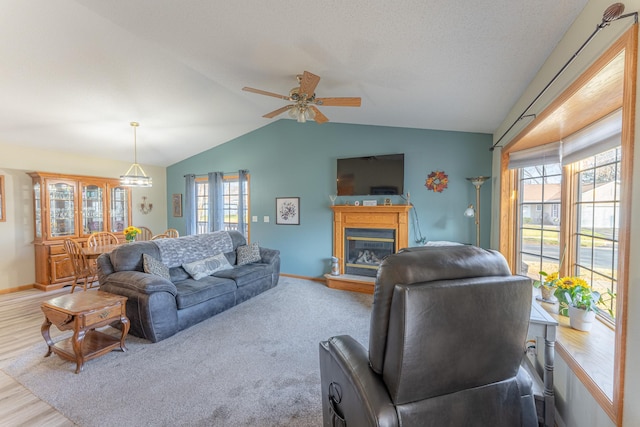 living room with a wealth of natural light, light hardwood / wood-style flooring, ceiling fan, and lofted ceiling