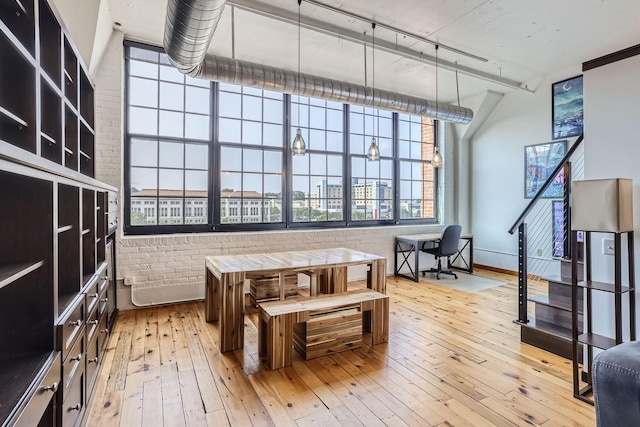 interior space with hardwood / wood-style floors and brick wall